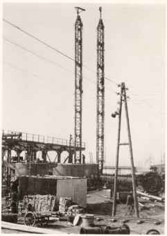 “In Picture 2, a column is lying at an angle in front of its concrete foudation, with the connection nozzles clearly visible. Two assembly towers have been positioned, with which the column is to be hoisted […] In the foreground of the picture, construction material in the form of stones is visible.”'(Photo 1943/44, description by I.G. Farben defense counsel, Wollheim lawsuit, 1955)'© Central State Archive of Hesse (records of Wollheim lawsuit)